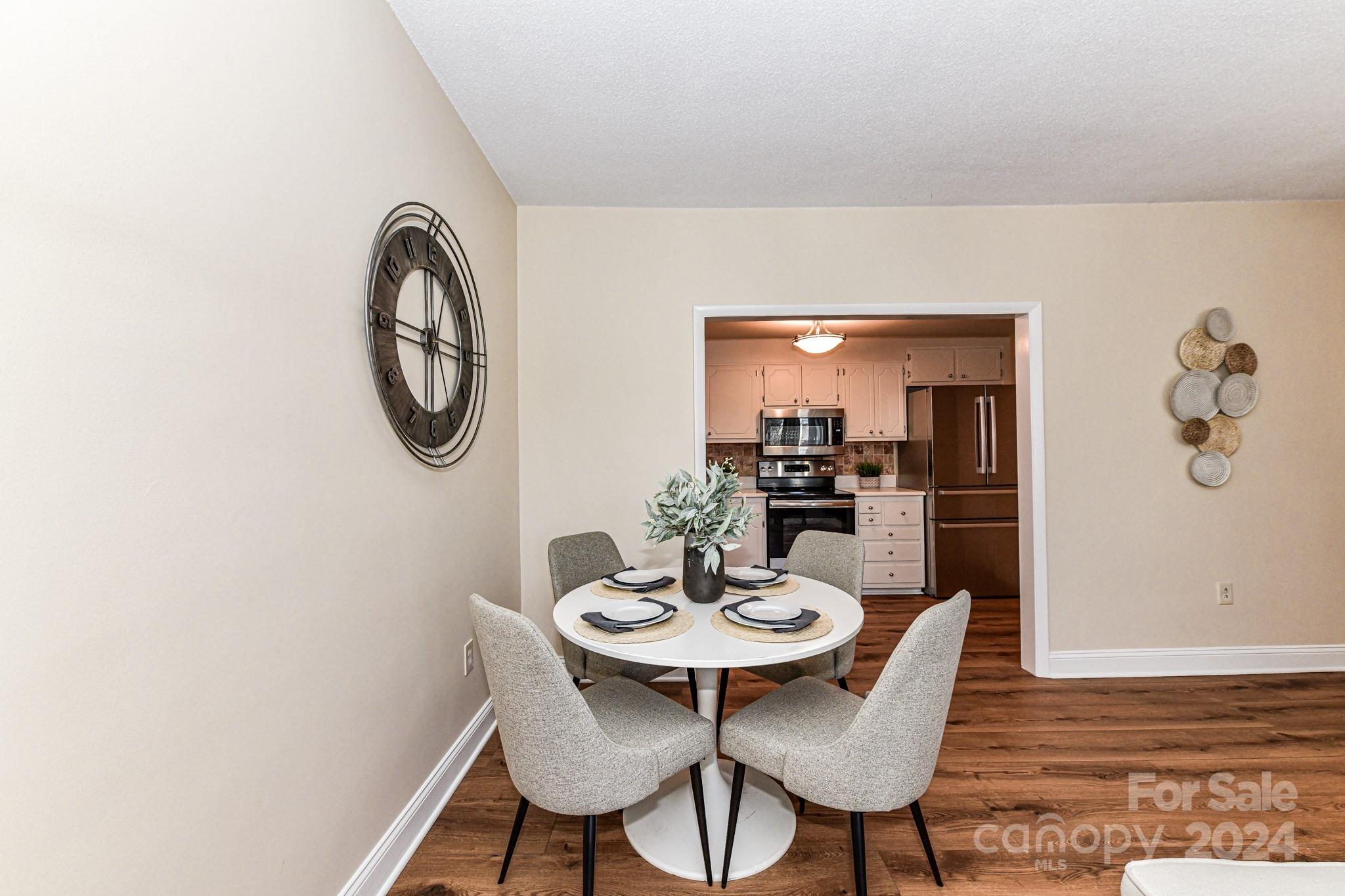 1300 Reece Road, Unit 415 Charlotte, NC 28209 - Photo 13 of 32 a view of a dining room with furniture and wooden floor