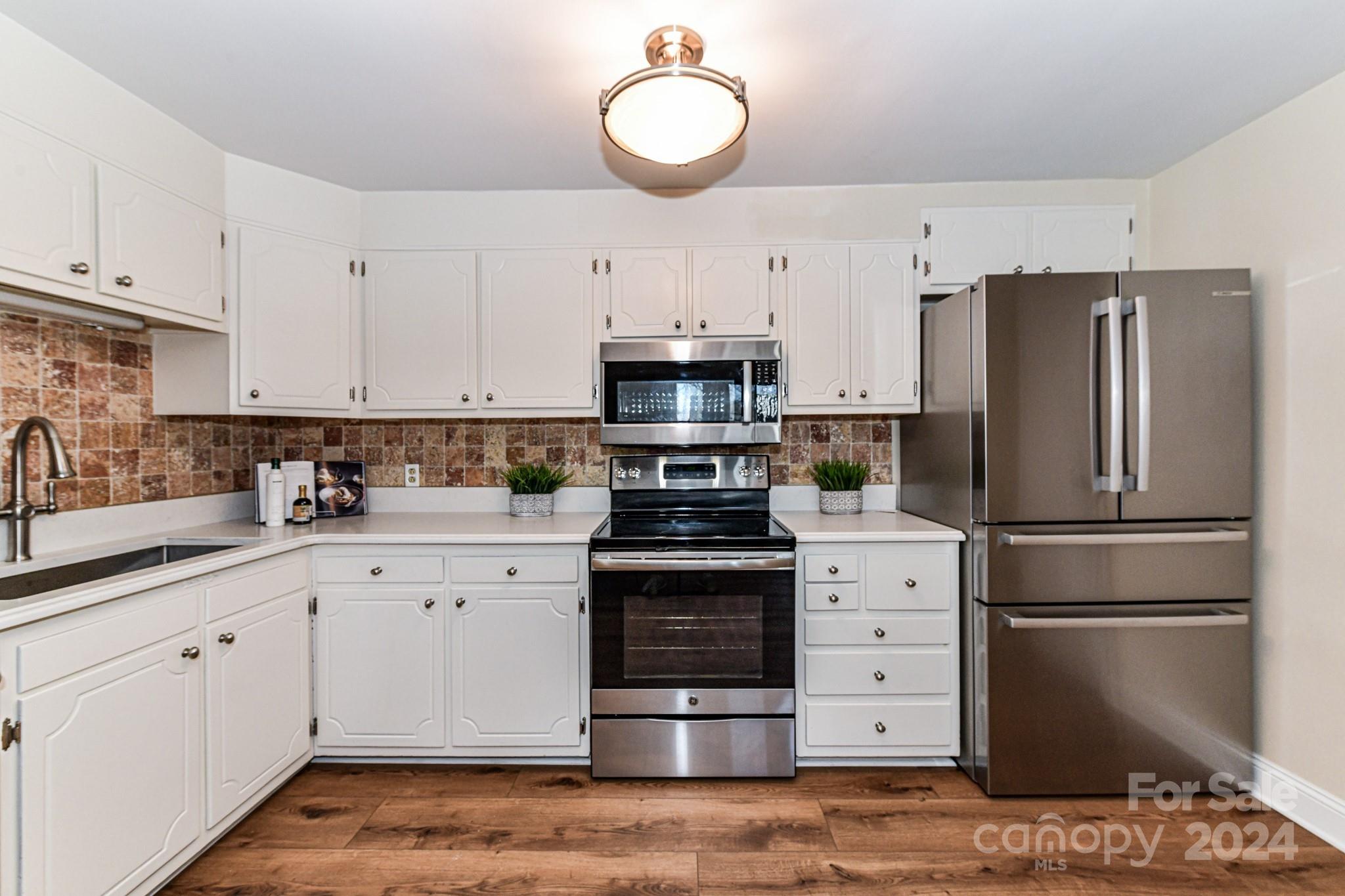 1300 Reece Road, Unit 415 Charlotte, NC 28209 - Photo 14 of 32 a kitchen with a stove refrigerator and a sink