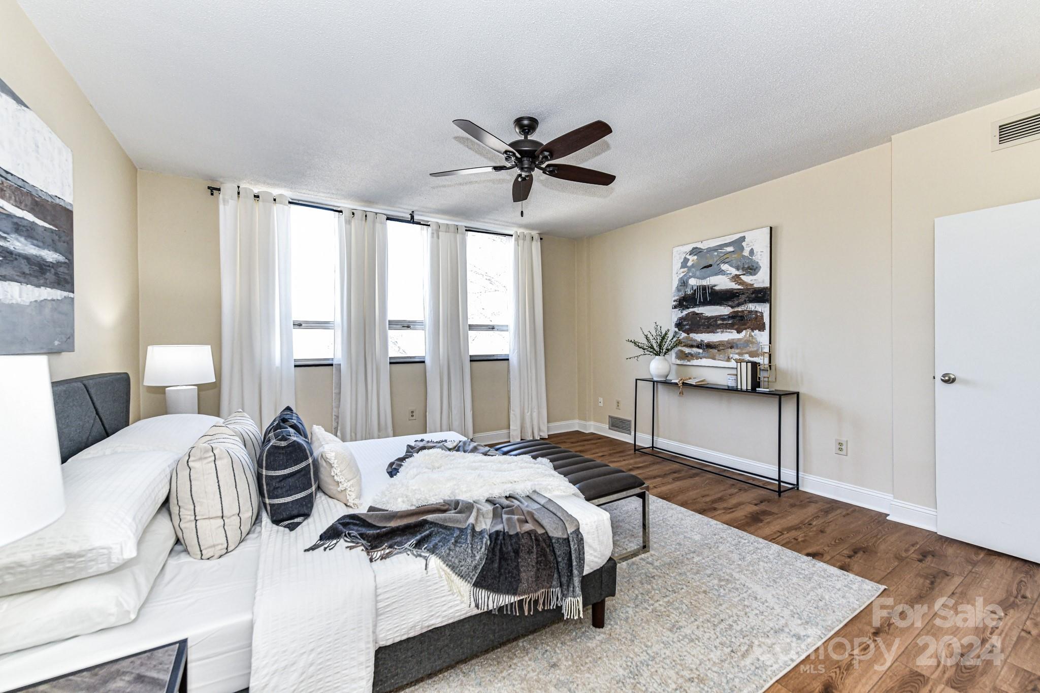 1300 Reece Road, Unit 415 Charlotte, NC 28209 - Photo 20 of 32 a bedroom with a bed a dresser and a large window