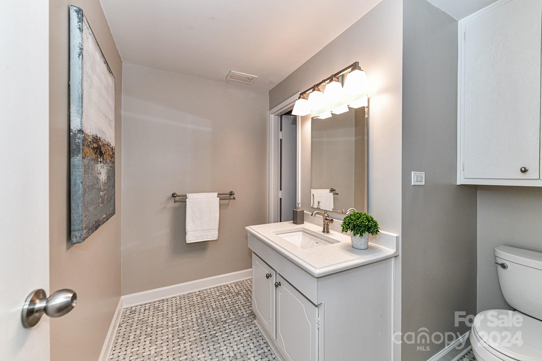 1300 Reece Road, Unit 415 Charlotte, NC 28209 - Photo 22 of 32 a bathroom with a granite countertop sink and a mirror
