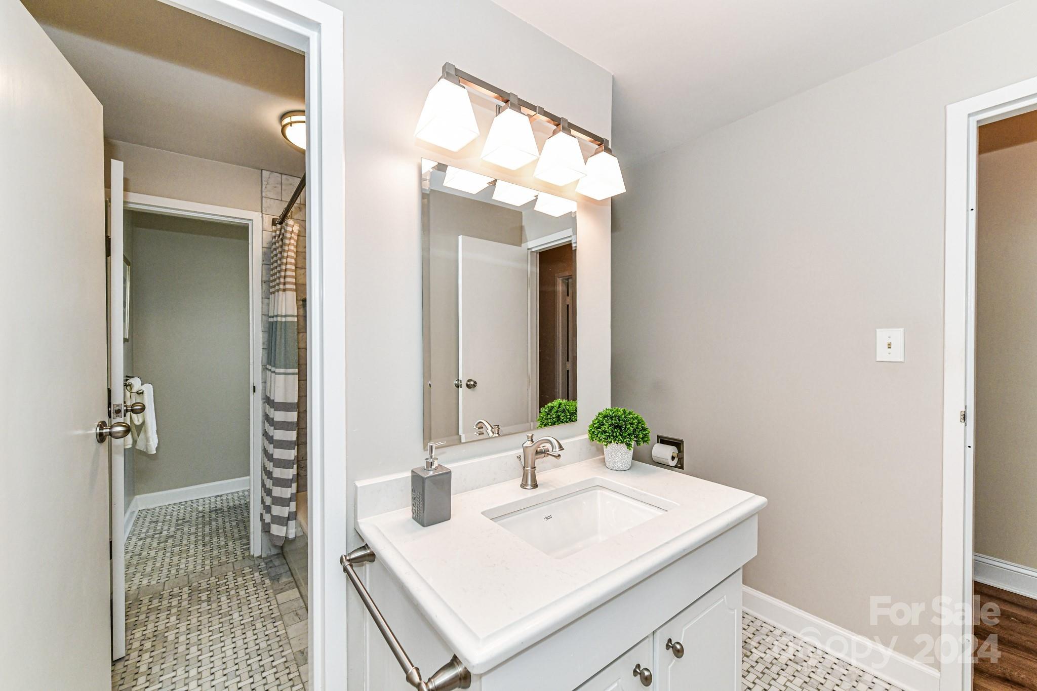 1300 Reece Road, Unit 415 Charlotte, NC 28209 - Photo 23 of 32 a bathroom with a sink vanity and a mirror