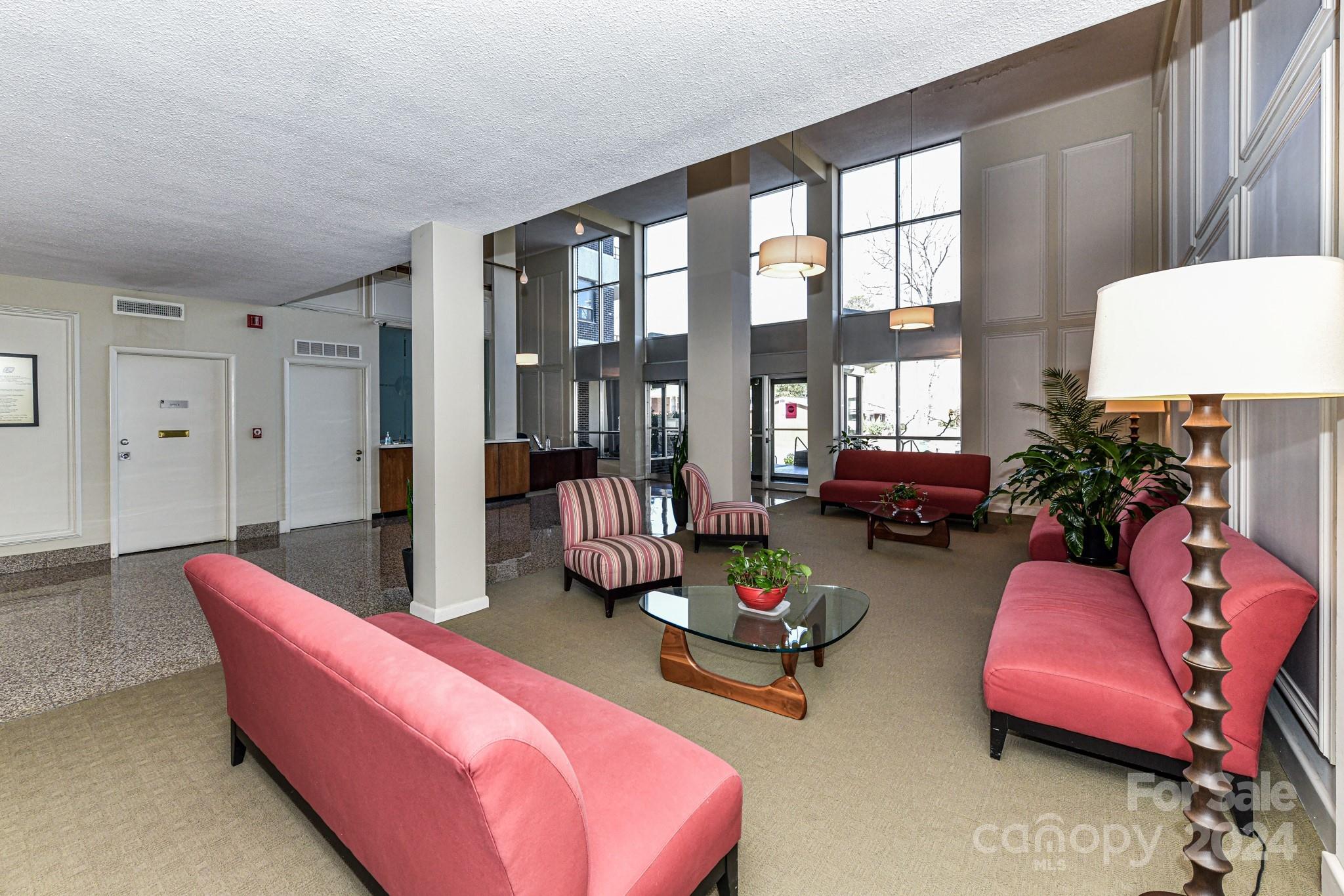 1300 Reece Road, Unit 415 Charlotte, NC 28209 - Photo 4 of 32 a living room with furniture and a floor to ceiling window