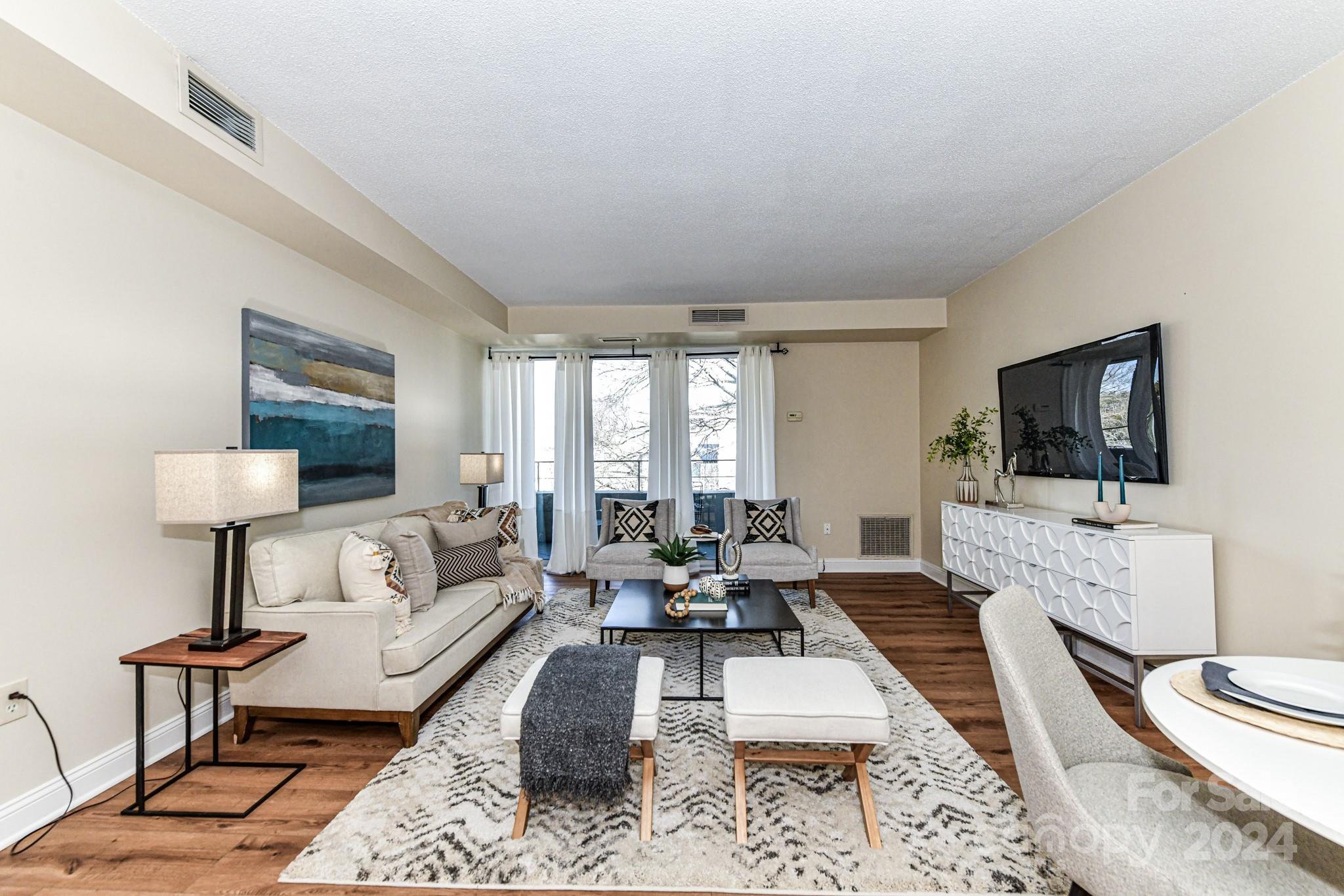 1300 Reece Road, Unit 415 Charlotte, NC 28209 - Photo 8 of 32 a living room with furniture and a flat screen tv