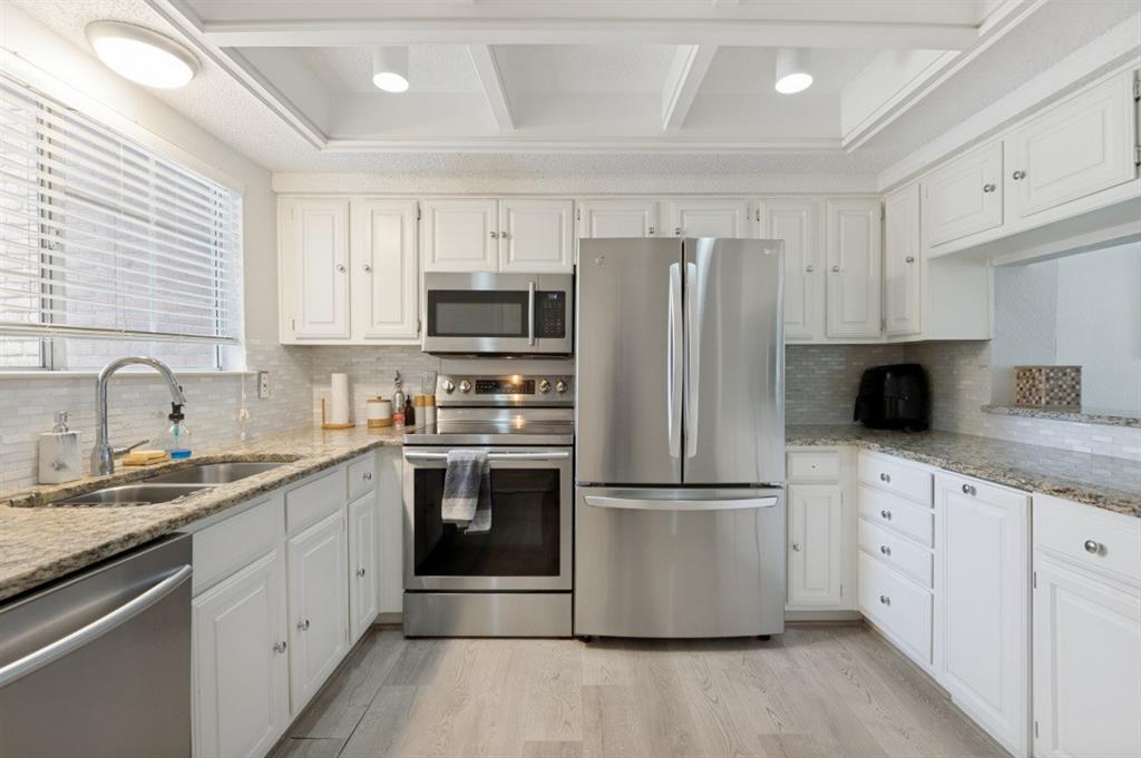4050 Frankford Road, Unit 908 Dallas, TX 75287 - Photo 5 of 24 Modern kitchen featuring white cabinetry, stainless steel French-door refrigerator, and built-in stainless steel appliances including double wall oven and microwave