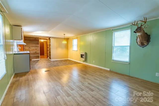 a view of a room and wooden floor and windows