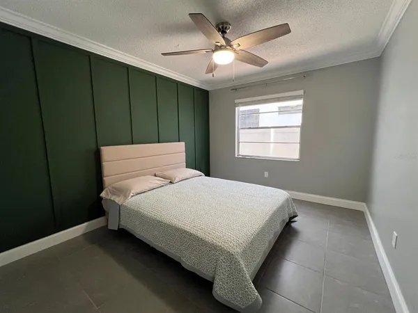 a bed sitting in a spacious bedroom next to a window