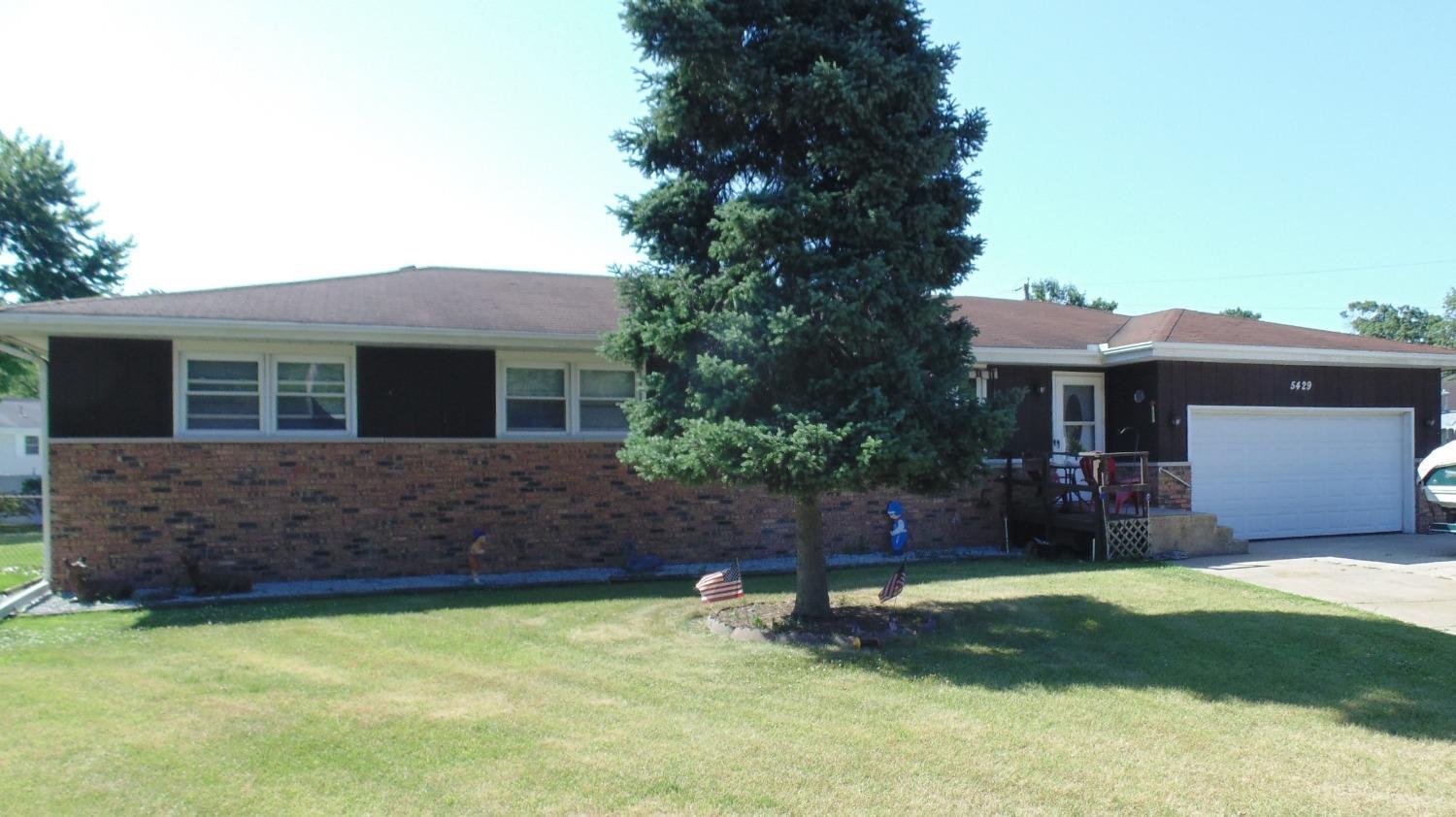 a view of house with a yard and a tree