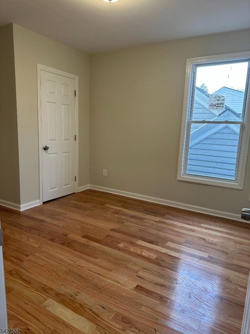 68 Arch Street Paterson, NJ 07522 - Photo 4 of 6 a view of an empty room with wooden floor and a window