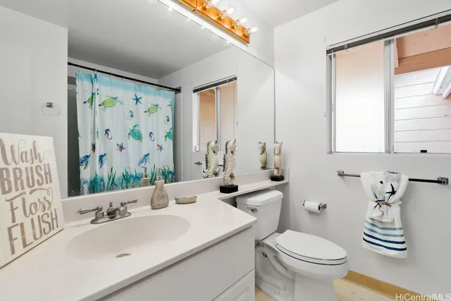 a bathroom with a sink a toilet and a mirror