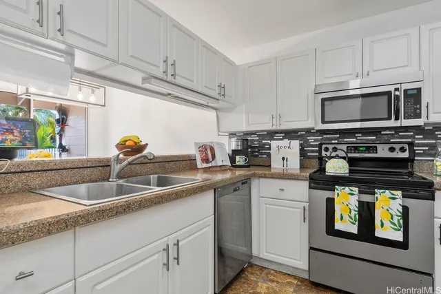a kitchen with stainless steel appliances granite countertop a sink stove and microwave