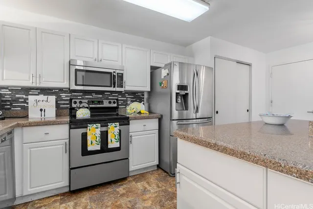 a kitchen with stainless steel appliances granite countertop a stove a microwave and refrigerator