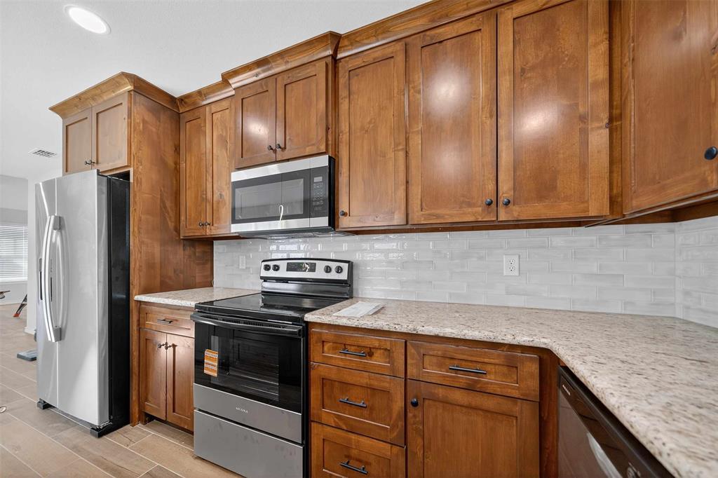 926 South Academy Avenue Tyler, TX 75701 - Photo 15 of 33 a kitchen with granite countertop cabinets stainless steel appliances and a counter space