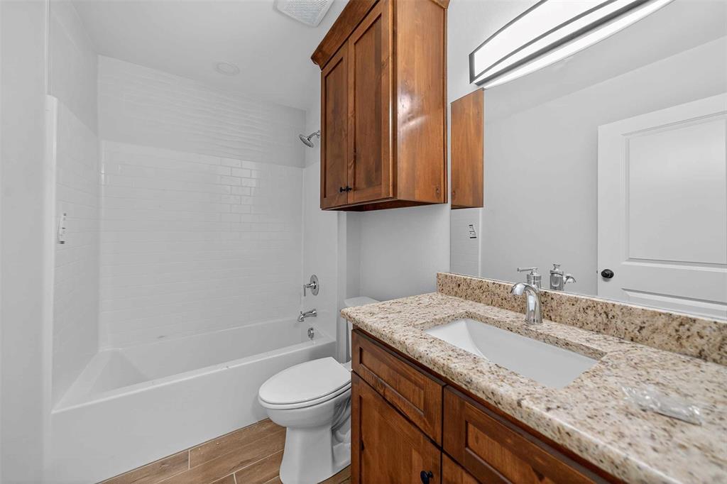 926 South Academy Avenue Tyler, TX 75701 - Photo 20 of 33 a bathroom with a granite countertop sink a toilet and bathtub