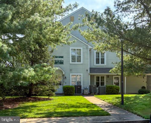 a view of a brick house with a yard and large trees