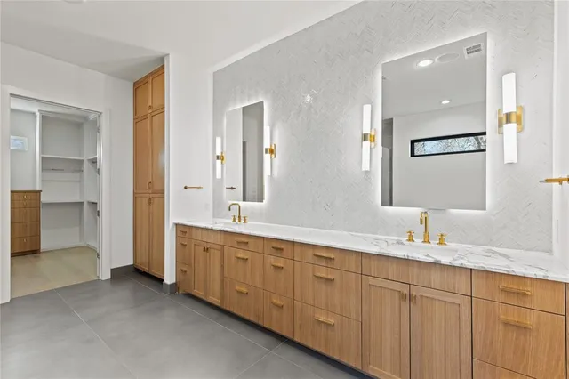 a bathroom with double vanity sinks a mirror and a shower