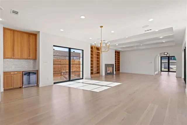 a view of an empty room with a kitchen and a window