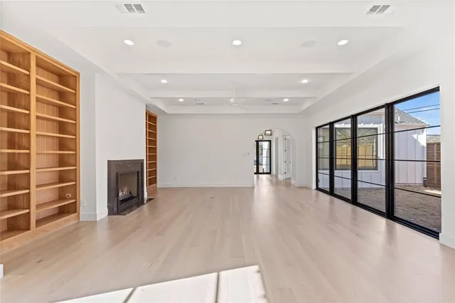 a view of an empty room with a fireplace and a window