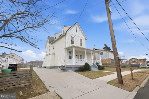 a view of a white house with wooden fence