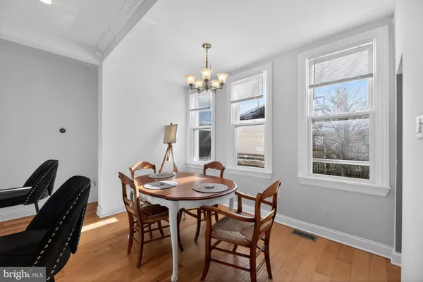 a dining room with furniture a chandelier and wooden floor