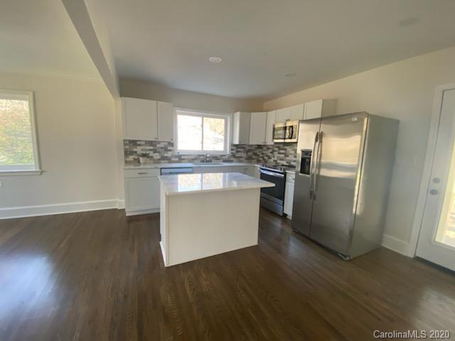 911 Scaleybark Road Charlotte, NC 28209 - Photo 3 of 22 a kitchen with stainless steel appliances granite countertop a refrigerator a stove top oven a sink and dishwasher with wooden floor