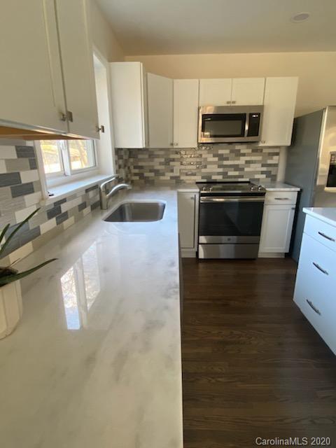 911 Scaleybark Road Charlotte, NC 28209 - Photo 6 of 22 a kitchen with a stove a sink and a microwave