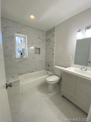 911 Scaleybark Road Charlotte, NC 28209 - Photo 10 of 22 a bathroom with a toilet a sink and bathtub