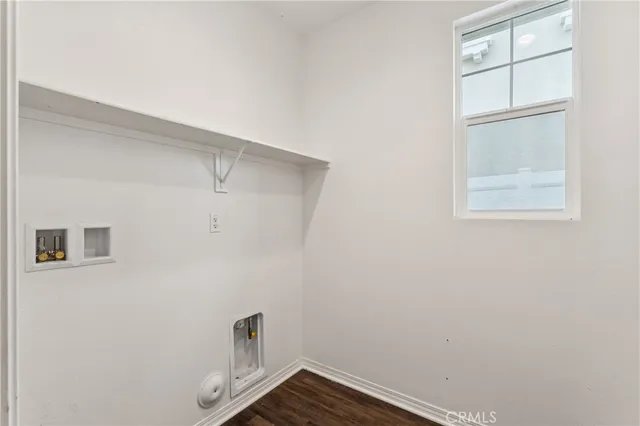 a view of a dining room and livingroom with furniture wooden floor a rug and a chandelier