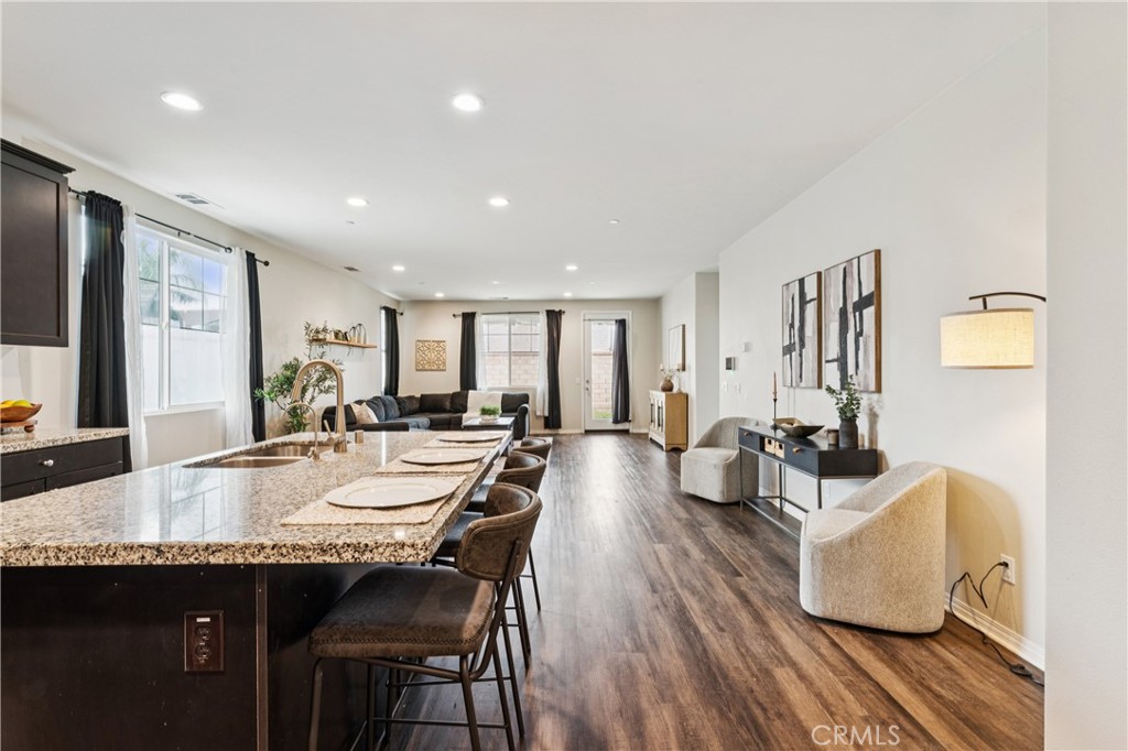 30535 Ridgely Way Menifee, CA 92584 - Photo 14 of 37 a view of a dining room and livingroom with furniture wooden floor a rug and a chandelier