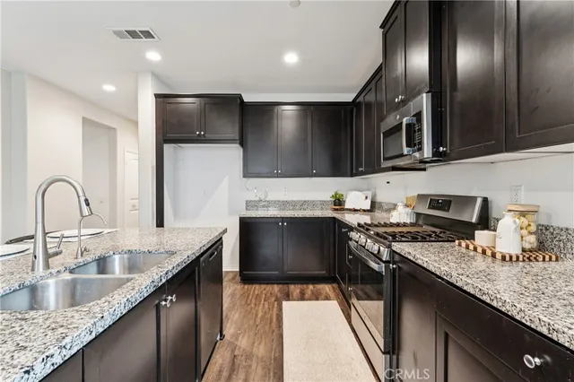 a kitchen with a sink and a wooden floor