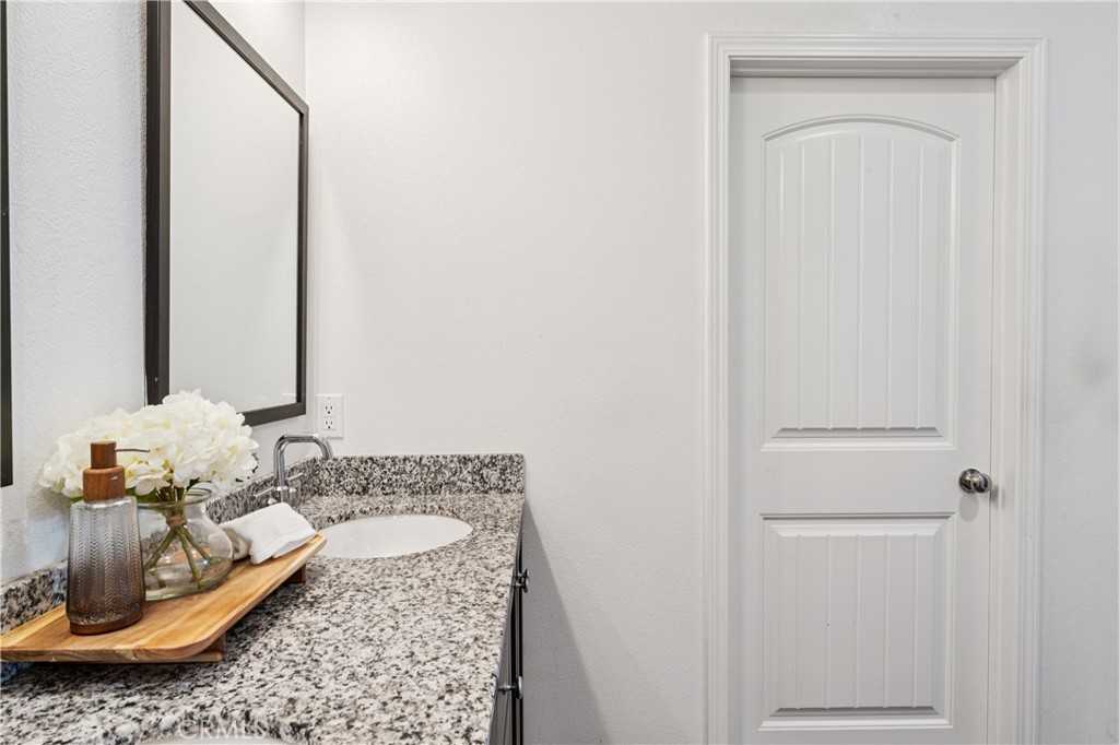 30535 Ridgely Way Menifee, CA 92584 - Photo 29 of 37 a bathroom with a granite countertop sink and a mirror