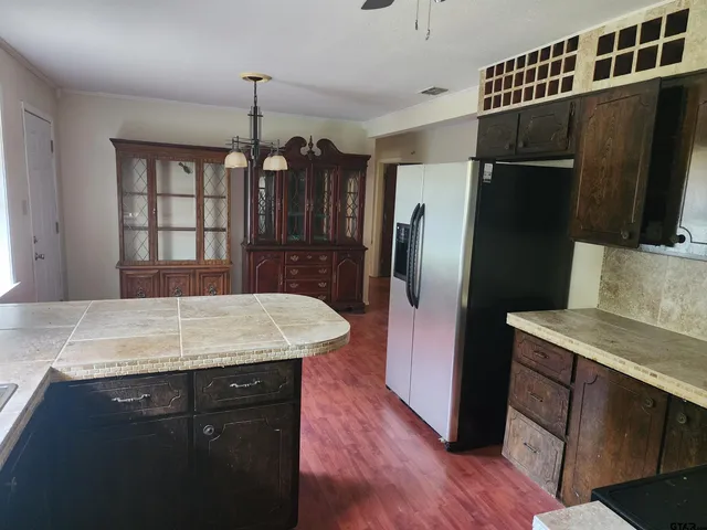 a kitchen with a refrigerator sink and wooden cabinets