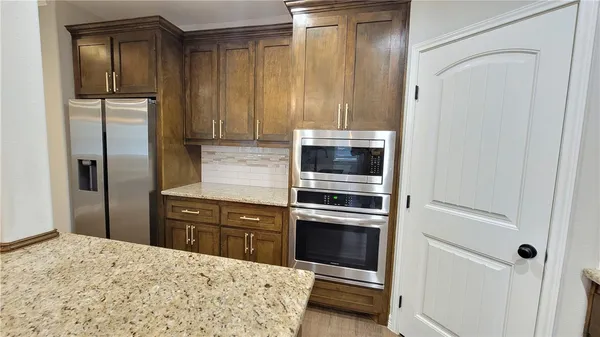 a kitchen with granite countertop cabinets and refrigerator