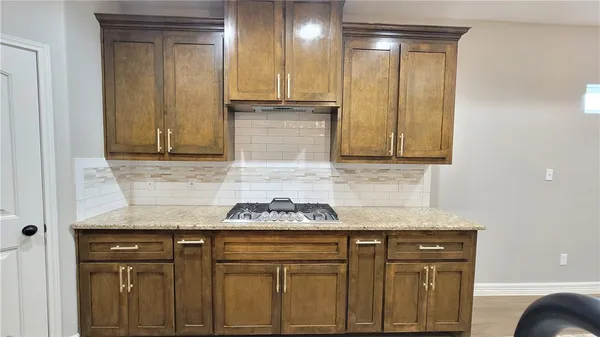a kitchen with granite countertop white cabinets and stainless steel appliances