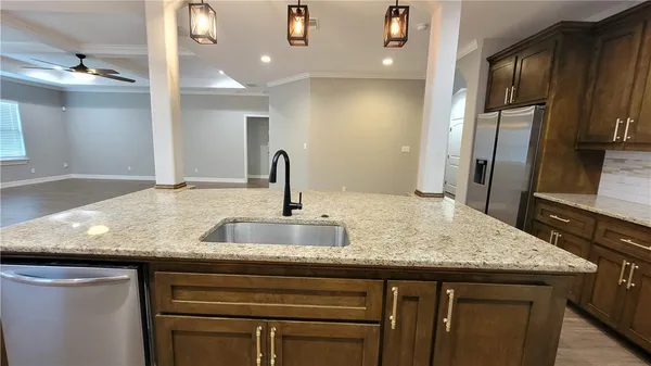 a kitchen with granite countertop a sink and stainless steel appliances