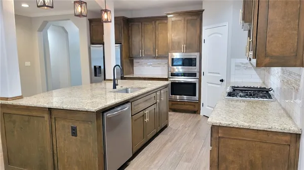 a kitchen with stainless steel appliances granite countertop a sink and cabinets