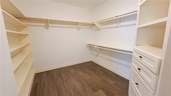 a view of walk in closet with empty racks