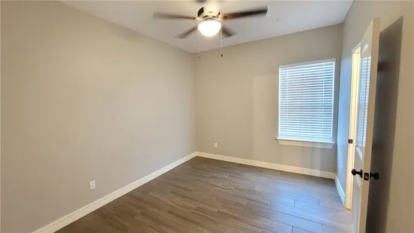 an empty room with wooden floor and a window
