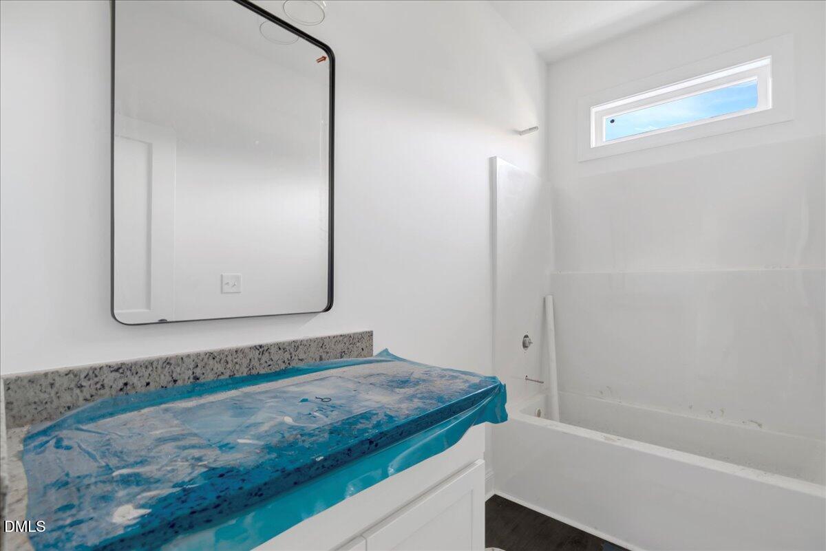 207 Terrell Street Norlina, NC 27563 - Photo 15 of 23 a bathroom with a granite countertop bathtub and a mirror