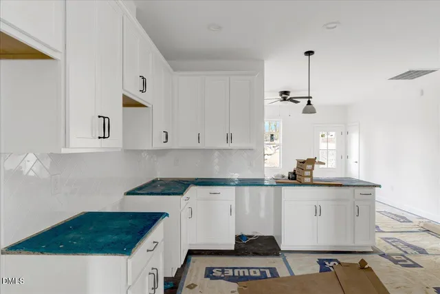 a kitchen with granite countertop a sink a stove and cabinets