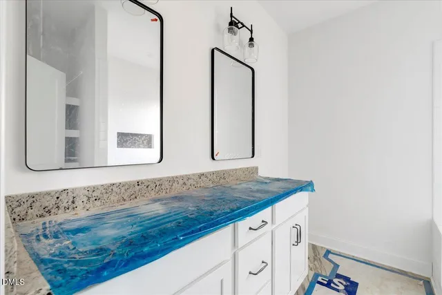 a bathroom with a granite countertop sink and mirror