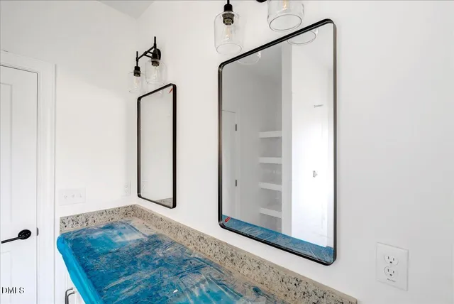 a view of a hallway with wooden floor and a bathroom