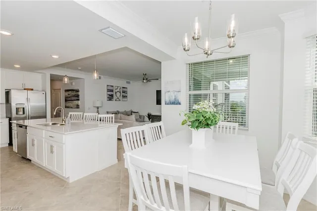 a kitchen with stainless steel appliances kitchen island granite countertop a table chairs and a refrigerator