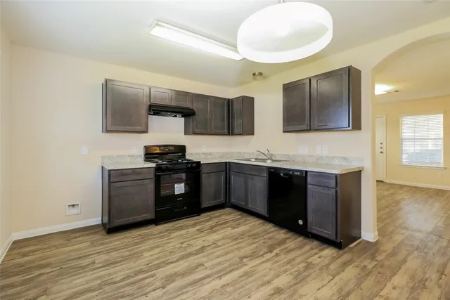 a kitchen with granite countertop a stove and cabinets