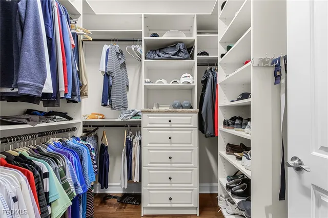 a view of walk in closet with clothes and shoes