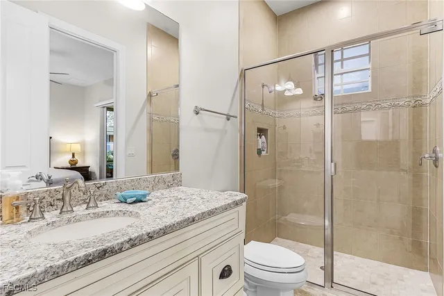 a bathroom with a granite countertop sink toilet and shower