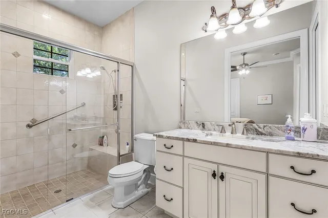 a bathroom with a granite countertop sink toilet a mirror a glass door shower and vanity