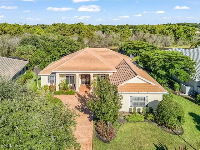 a front view of a house with a yard and potted plants