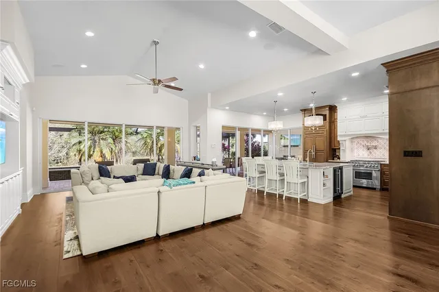 a living room with furniture a large window and wooden floors