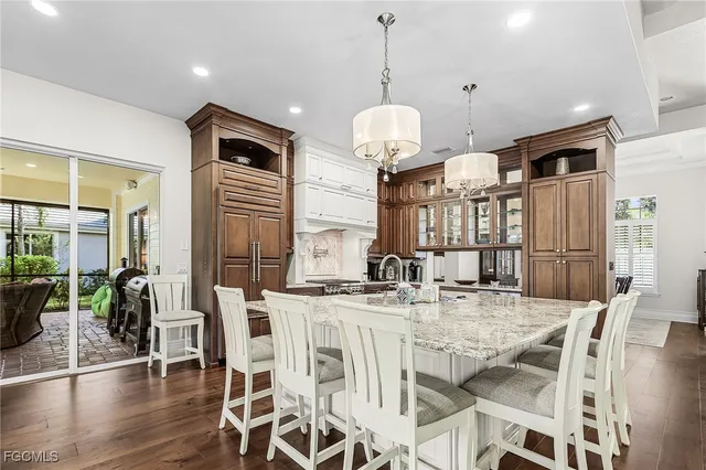 a view of a dining room and livingroom with furniture wooden floor a chandelier