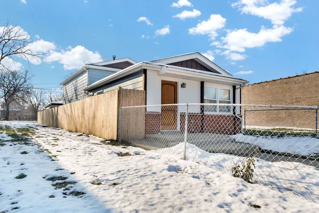 a front view of a house with a yard covered in snow